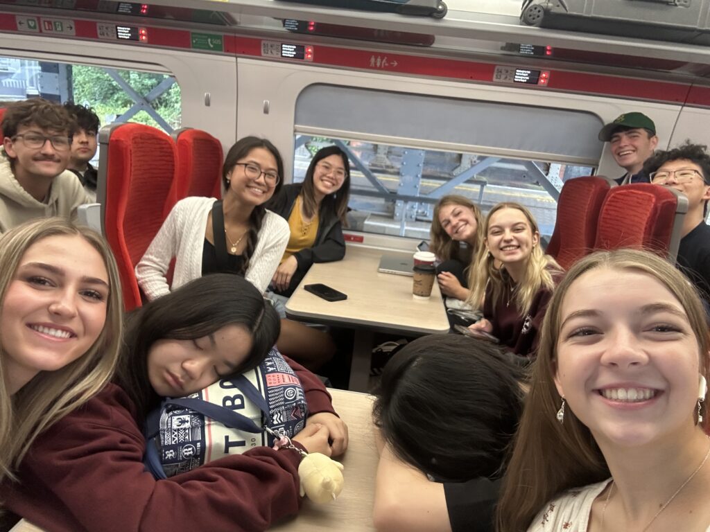 Students smiling at the camera while on the train.