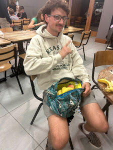 A student placing fruit in his bag.