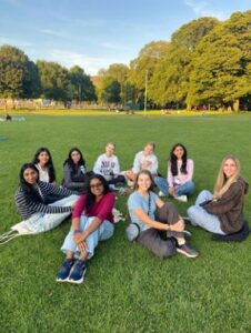 A group of female students sitting in the grass.